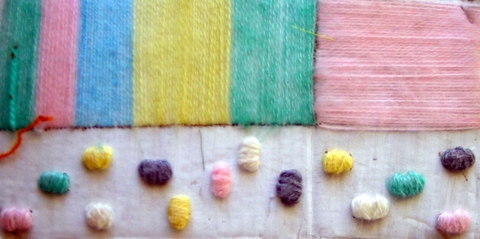 Obra textil: Materiales: hilos de lana de diferentes grosores y cartón. 